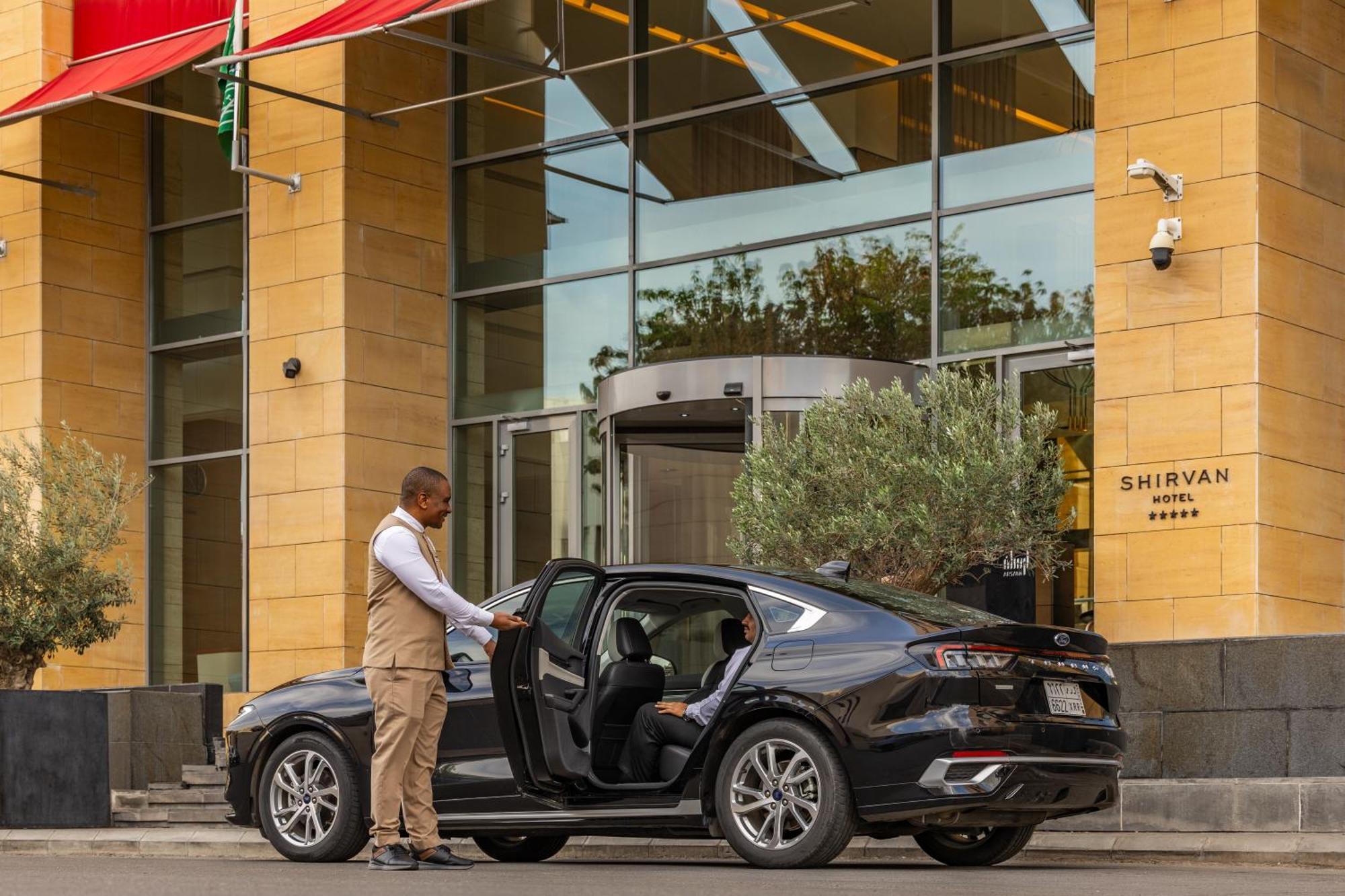 Shirvan Hotel City Yard ジェッダ エクステリア 写真 A chauffeur opening the door of a car